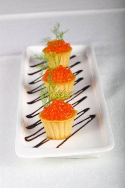 Beyaz masada kırmızı havyar tartalets