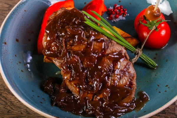 Beef steak with sauce served vegetables