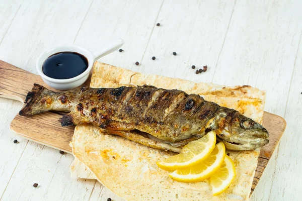 Grilled trout with lemon and sauce