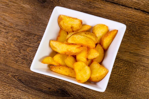 Ahşap arka plan üzerinde rustik lezzetli patates