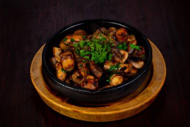 Otlar ile tavada kavrulmuş mantar