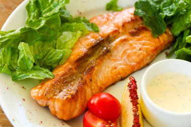 Izgara somon steak sos ve salata yaprakları ile