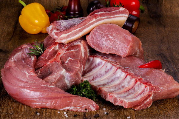 Raw pork meat over wooden background