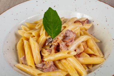 Pastırma ve fesleğen yaprakları ile penne