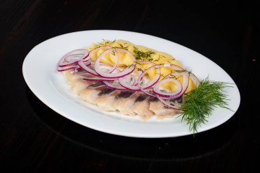 Patates ve soğan ile ringa balığı filetosu