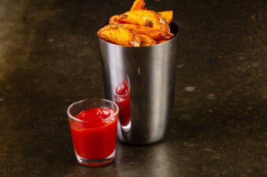 Ahşap arka plan üzerinde soslu kızarmış patates