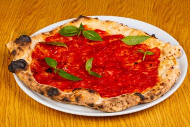 Pizza chorizo ve fesleğen yaprakları ile