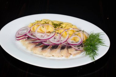 Patates ve soğan ile ringa balığı filetosu