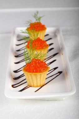 Beyaz masada kırmızı havyar tartalets
