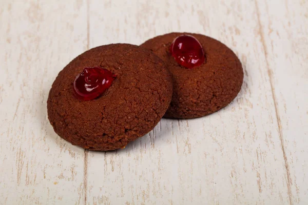 Chocolade cookies with jam over wooden background