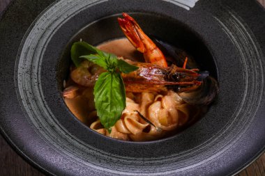 Fesleğen yaprakları ile deniz ürünleri makarna