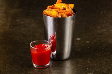 Ahşap arka plan üzerinde soslu kızarmış patates