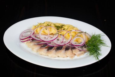 Patates ve soğan ile ringa balığı filetosu
