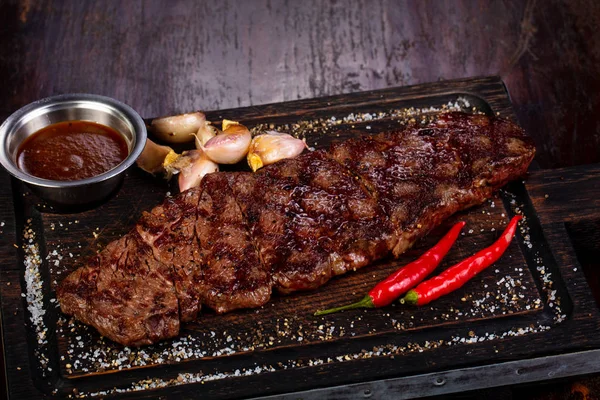 Grilled beef steak with sauce and pepper