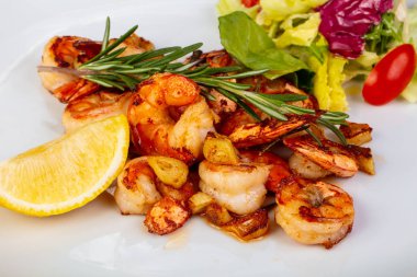 Marul ve limonlu lezzetli kavrulmuş karidesler.