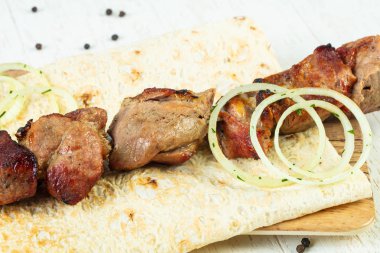 Grilled pork kebab with onion and sauce clipart