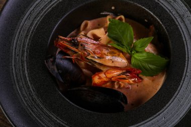 Fesleğen yaprakları ile deniz ürünleri makarna