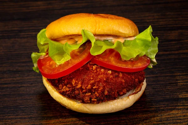 Tasty hot burger over wooden background