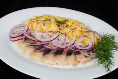 Patates ve soğan ile ringa balığı filetosu