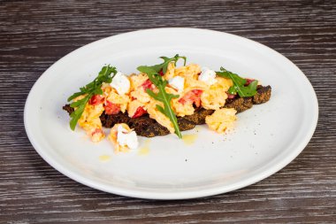 Yumurta, peynir ve domates ekmek üzerinde lezzetli scramble