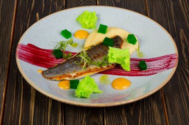 Kızarmış levrek balık fileto salata yaprakları ile