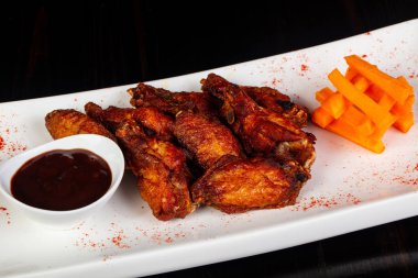 BBQ chicken wings with sauce and carrots clipart