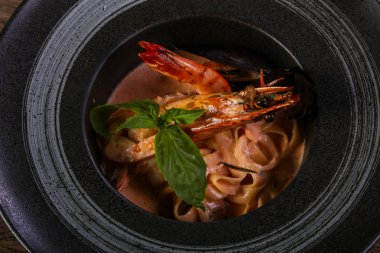 Fesleğen yaprakları ile deniz ürünleri makarna