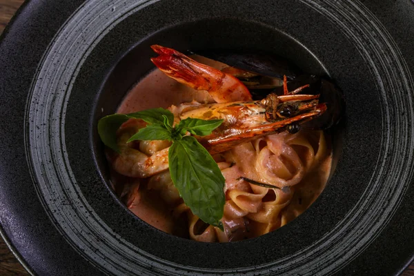 Fesleğen yaprakları ile deniz ürünleri makarna