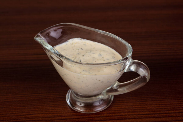 Tartar sauce in the bowl over wooden background