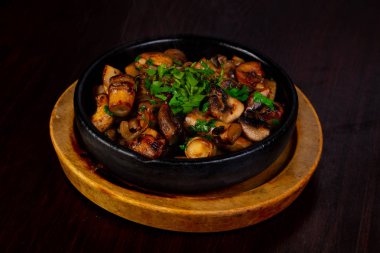 Otlar ile tavada kavrulmuş mantar