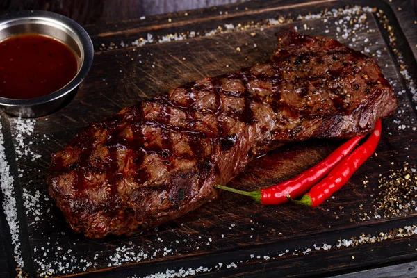 Grilled beef steak with sauce and pepper