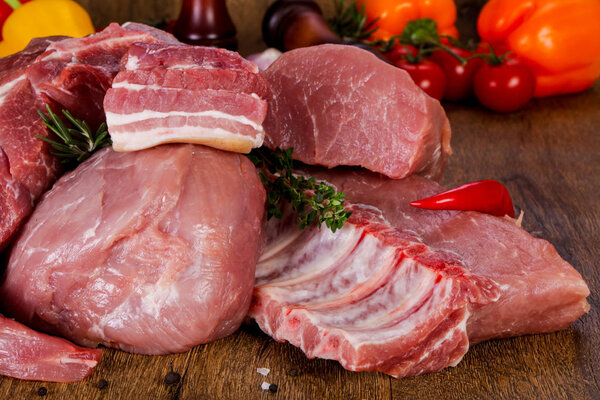 Raw pork meat over wooden background