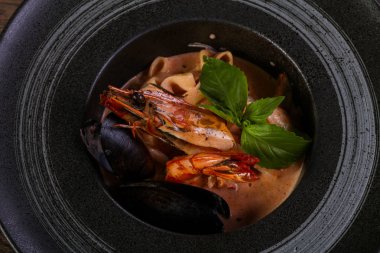 Fesleğen yaprakları ile deniz ürünleri makarna