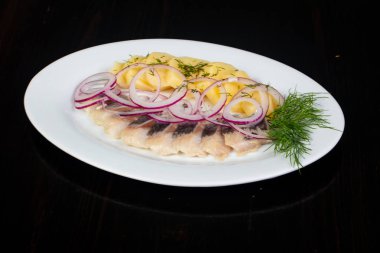 Patates ve soğan ile ringa balığı filetosu