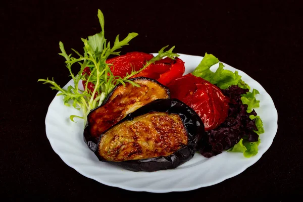 Grilled eggplant with tomato served salad leaves