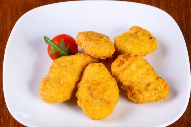 Tavuk nugget yığını, vişneli domates.