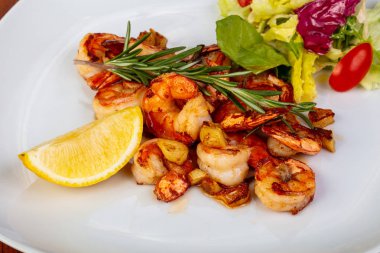 Marul ve limonlu lezzetli kavrulmuş karidesler.