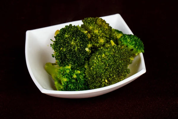 Steamed broccoli in the plate - vegan cuisine
