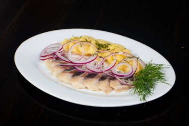 Patates ve soğan ile ringa balığı filetosu