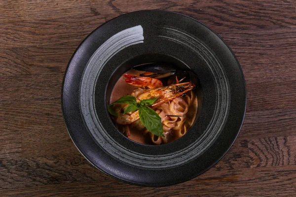 Fesleğen yaprakları ile deniz ürünleri makarna