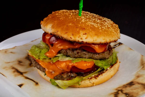 Tasty beef burger with sauce and lettuce