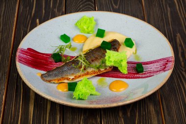 Kızarmış levrek balık fileto salata yaprakları ile