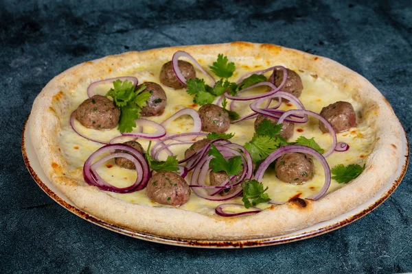 Pizza with meat balls and red onion