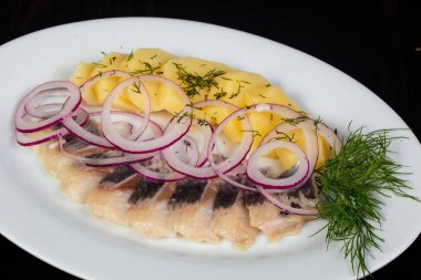 Patates ve soğan ile ringa balığı filetosu
