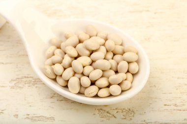 Kase ahşap arka plan üzerinde beyaz kuru fasulye