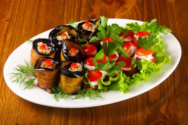 Doldurulmuş patlıcan ve domates salata yaprakları servis