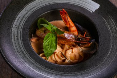 Fesleğen yaprakları ile deniz ürünleri makarna