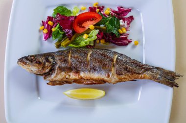 Salata ve limon karışımı ile ızgara levrek