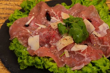 Parmesan peynirli ve salata yapraklı biftek carpaccio.