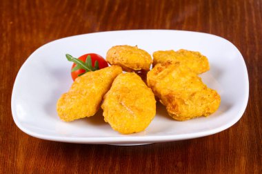 Tavuk nugget yığını, vişneli domates.